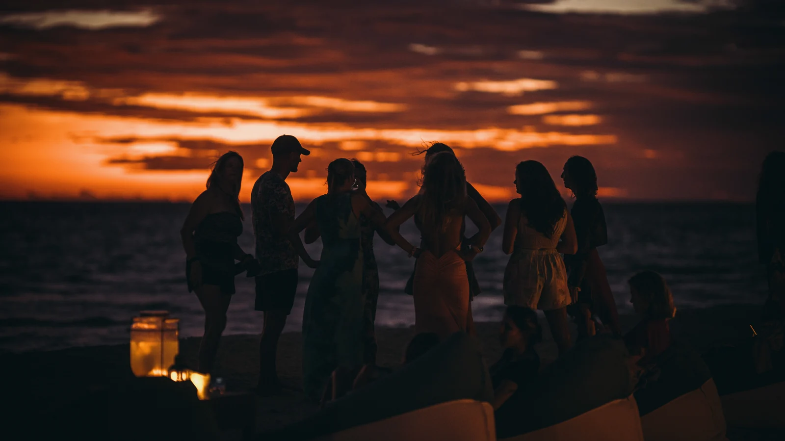 Behind the Mask community gathered on the beach at sunset